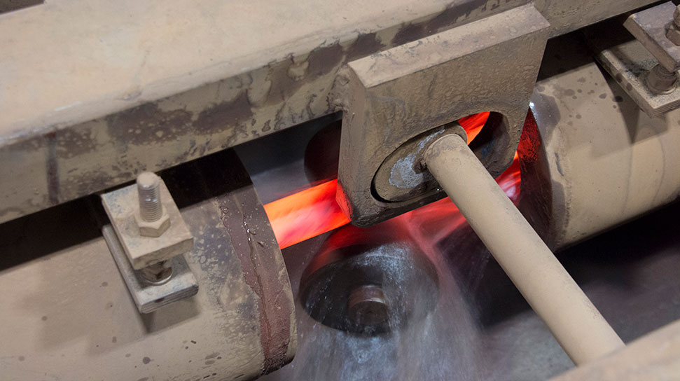 A glowing red (hot) piece of steel is placed on a workpiece to rapidly cool with water. This is process is known as quenching.